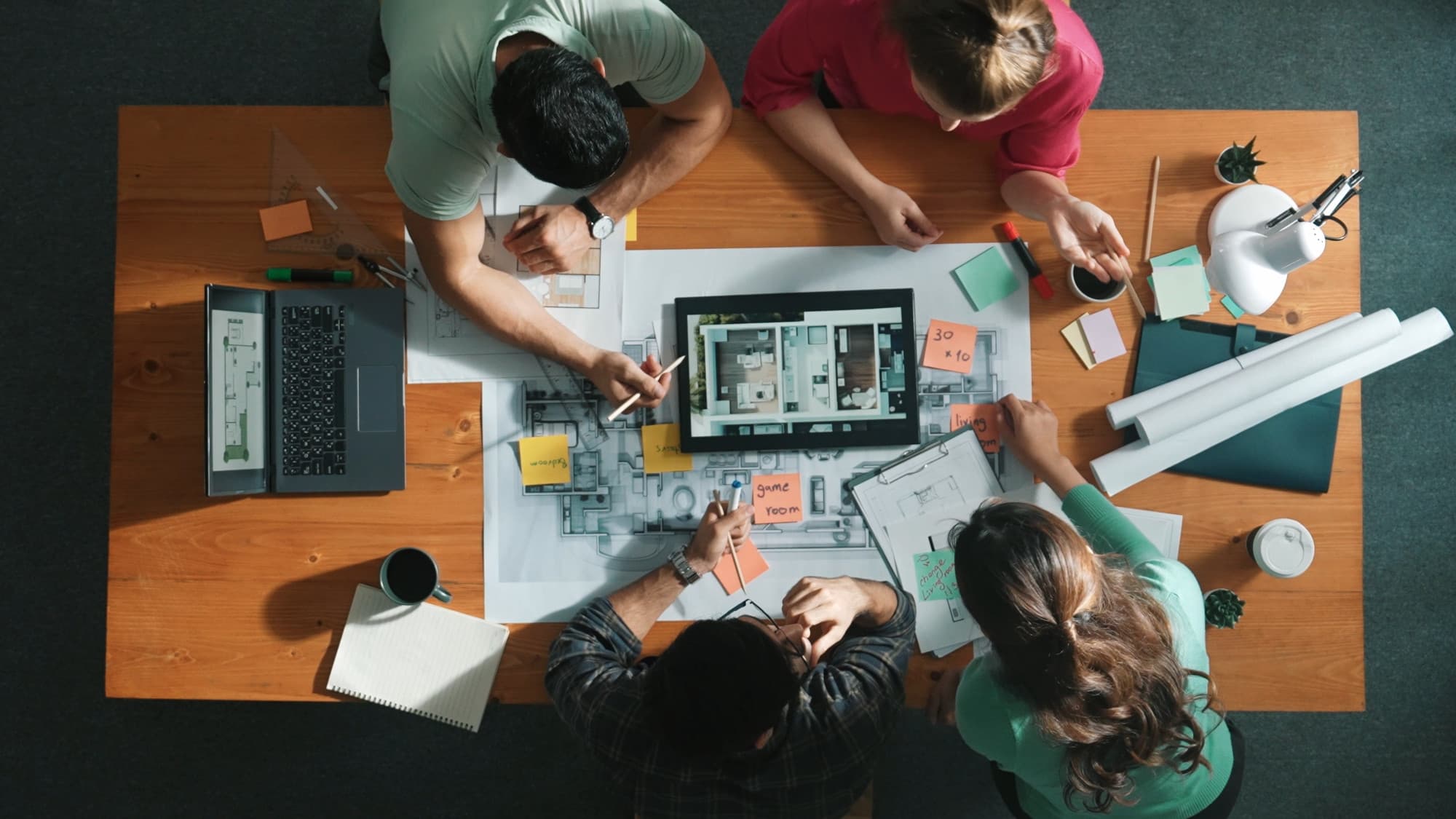 Project planning session — overhead view of team around blueprints